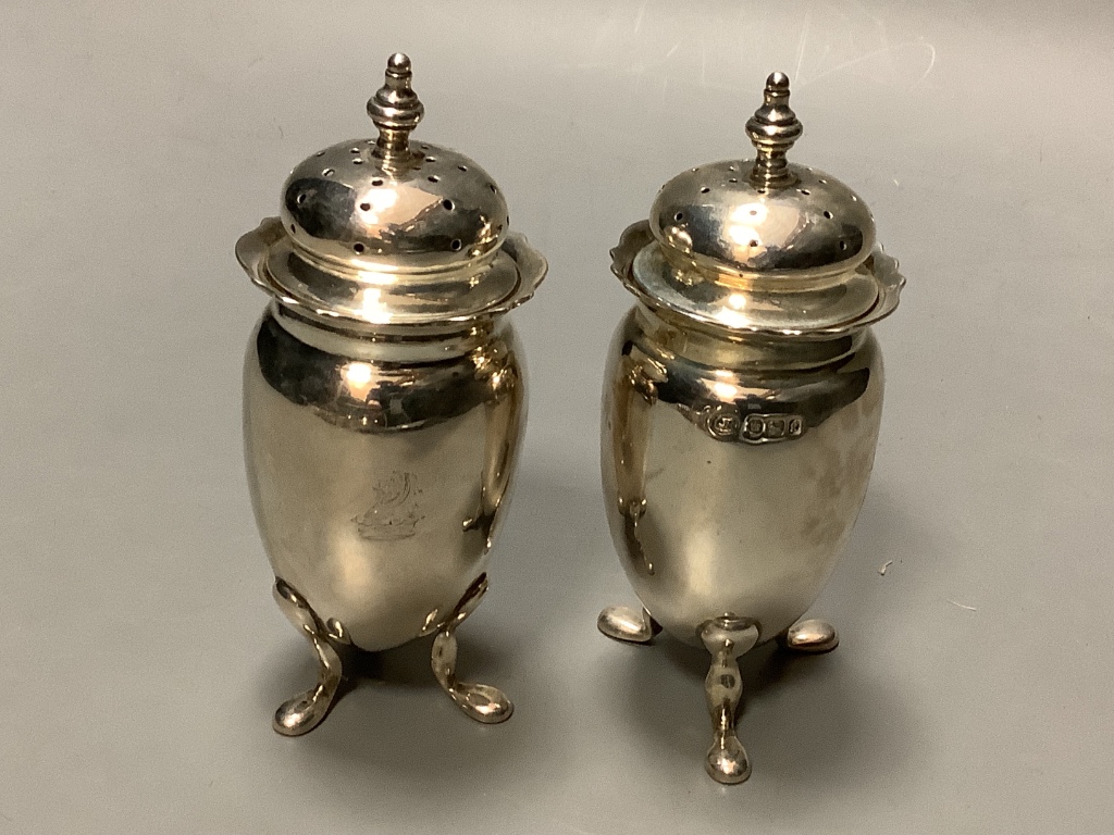 A pair of George V silver pepperettes, a pair of silver salts, and two silver mustard pots.